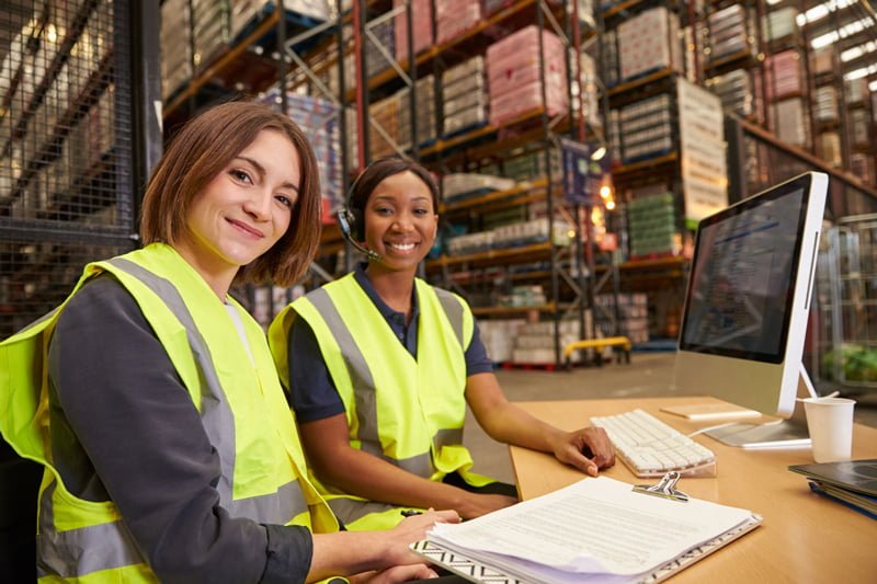 Two female customer service employees in a warehouse.